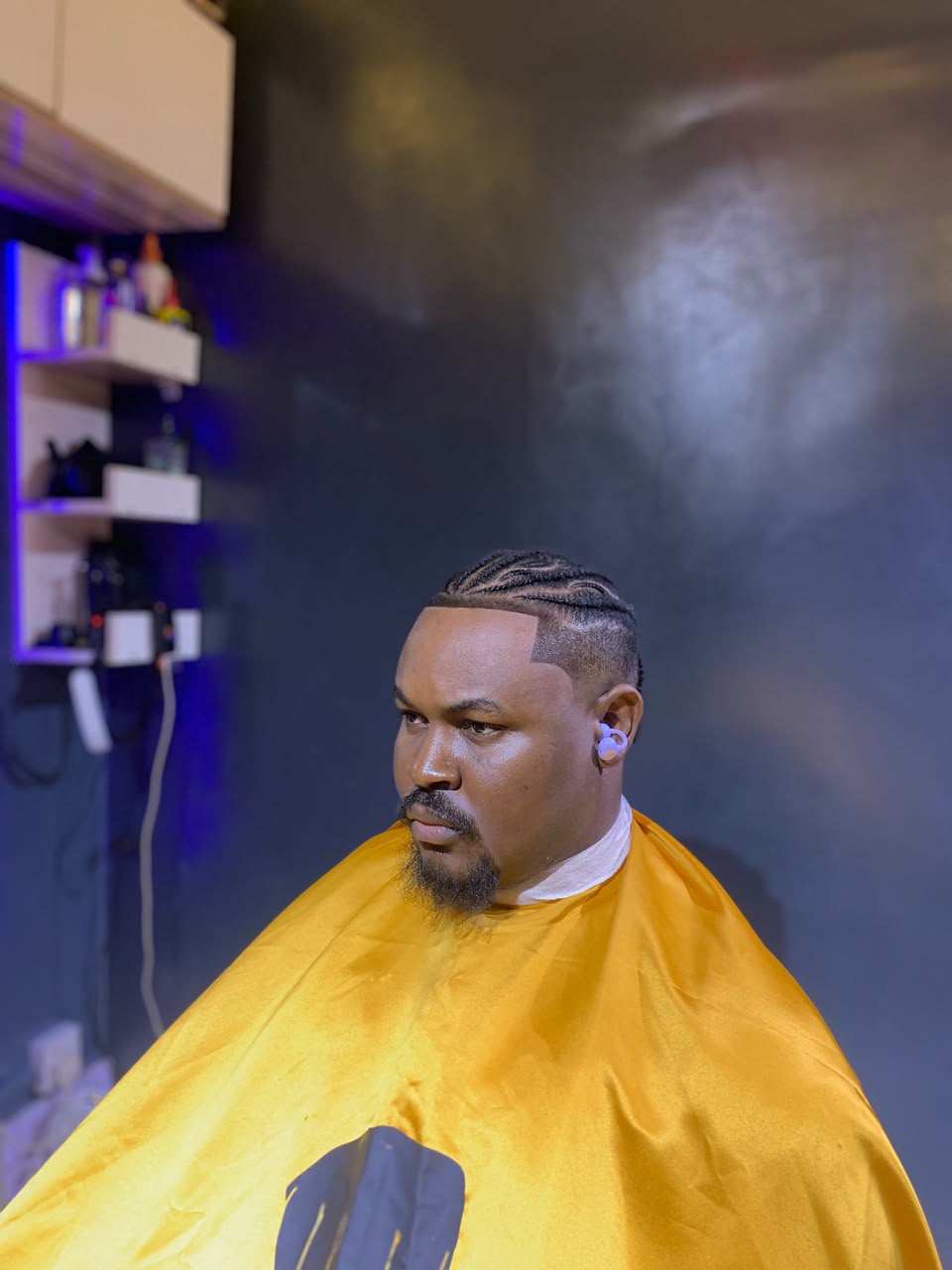 Cornrow hairstyle with a yellow YOUNGCUT cape